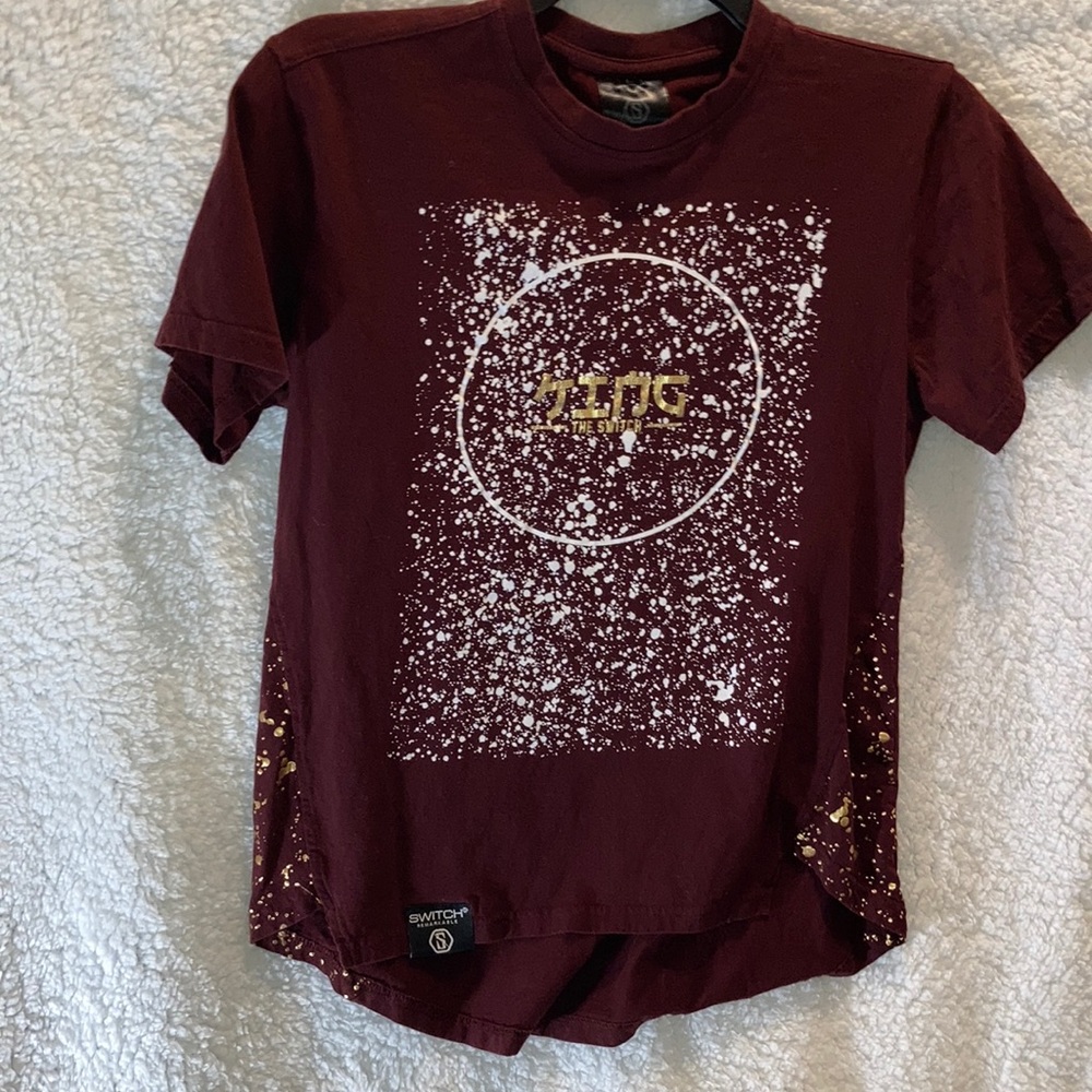 A maroon shirt with a white facing short sleeve